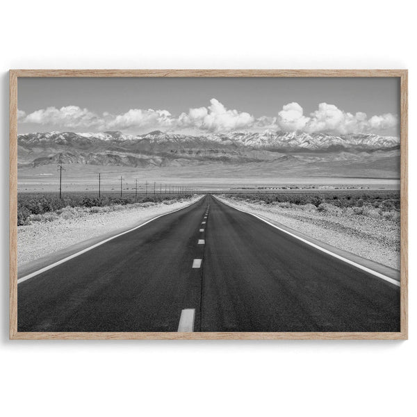This stunning piece of black and white desert wall art will take your breath away. A beautifully framed picture of a Death Valley National Park road leading towards the snow-covered mountains at the end of the desert.