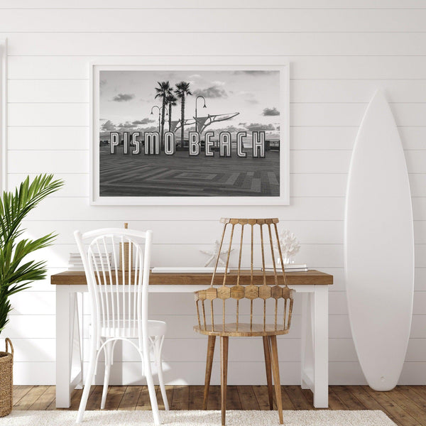 a fine art black and white modern beach print featuring the famous Pismo Beach sign in sunset with palm trees and the ocean in the backdrop,