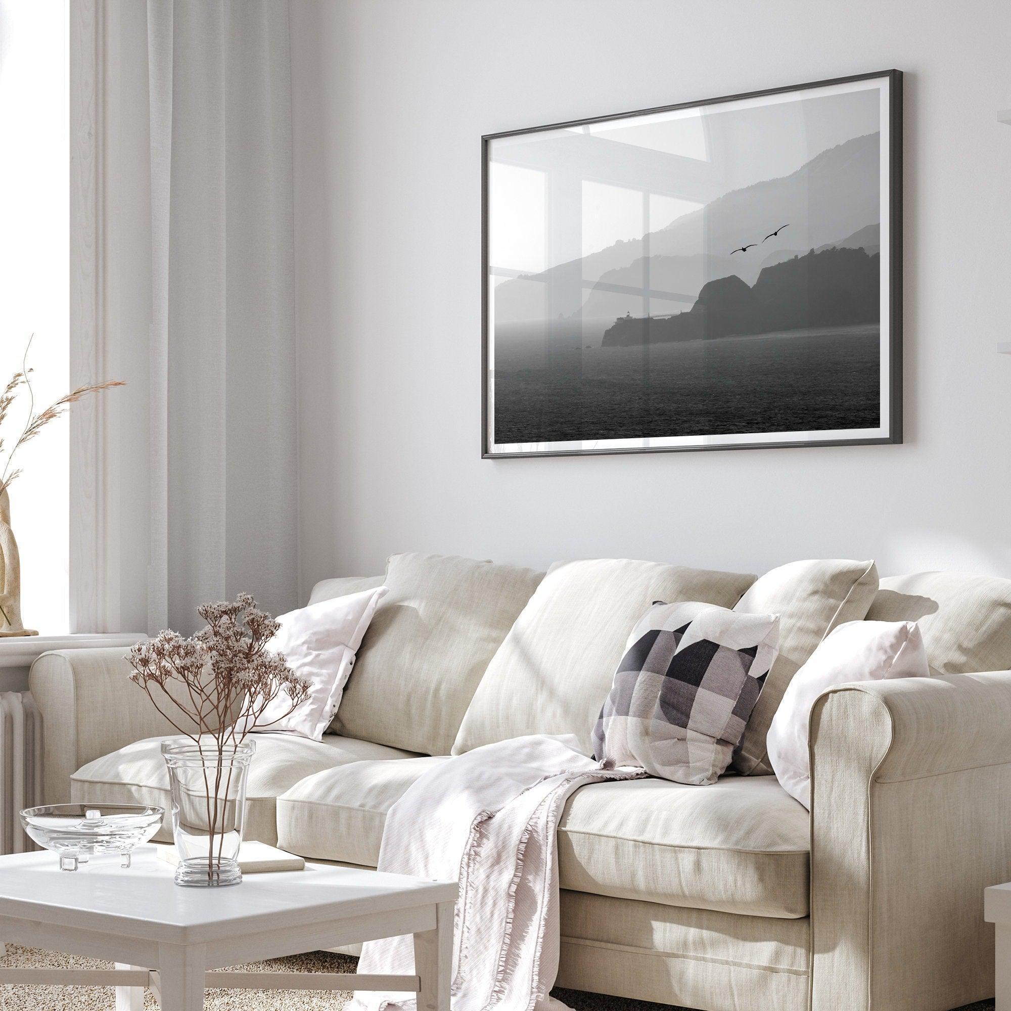 A black and white coastal wall art that showcases two Pelicans flying over the Pacific Ocean near the Golden Gate Bridge toward the layered mountains in the sunset.