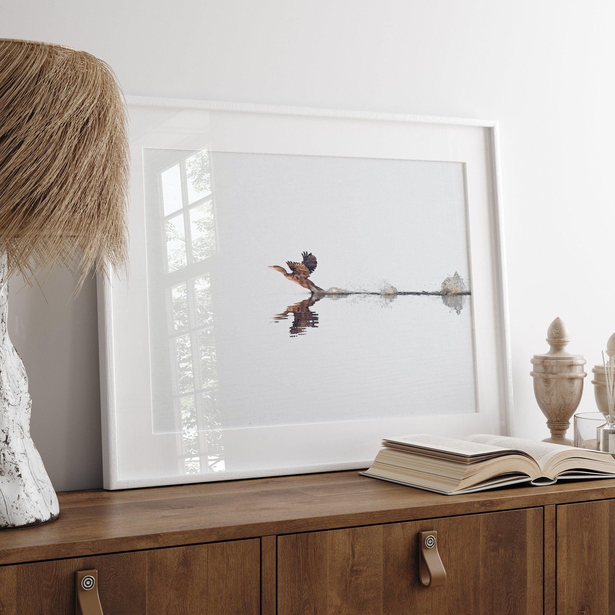 A fine art minimalist wildlife photography print showcasing a bird flying over a lake in Arizona.