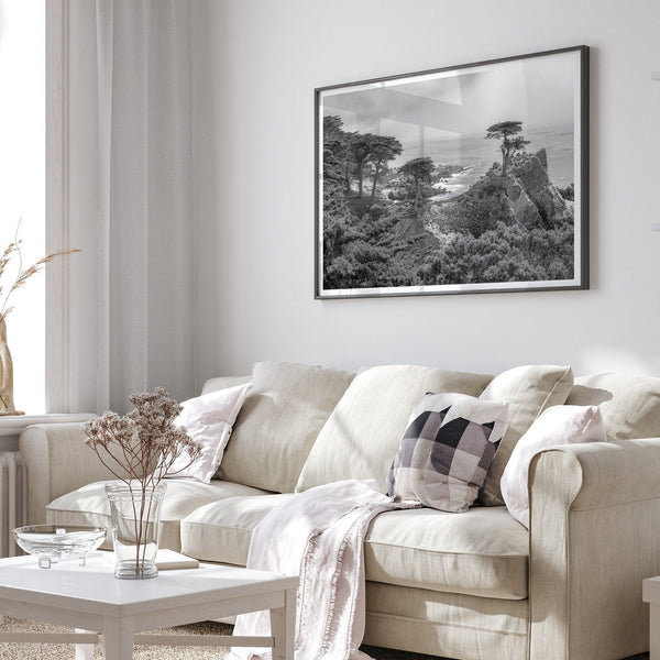 A fine art coastal black and white print showcasing a lone cypress overlooking the ocean in 17 mile drive near Monterey, California. This ocean wall art is available framed or unframed.