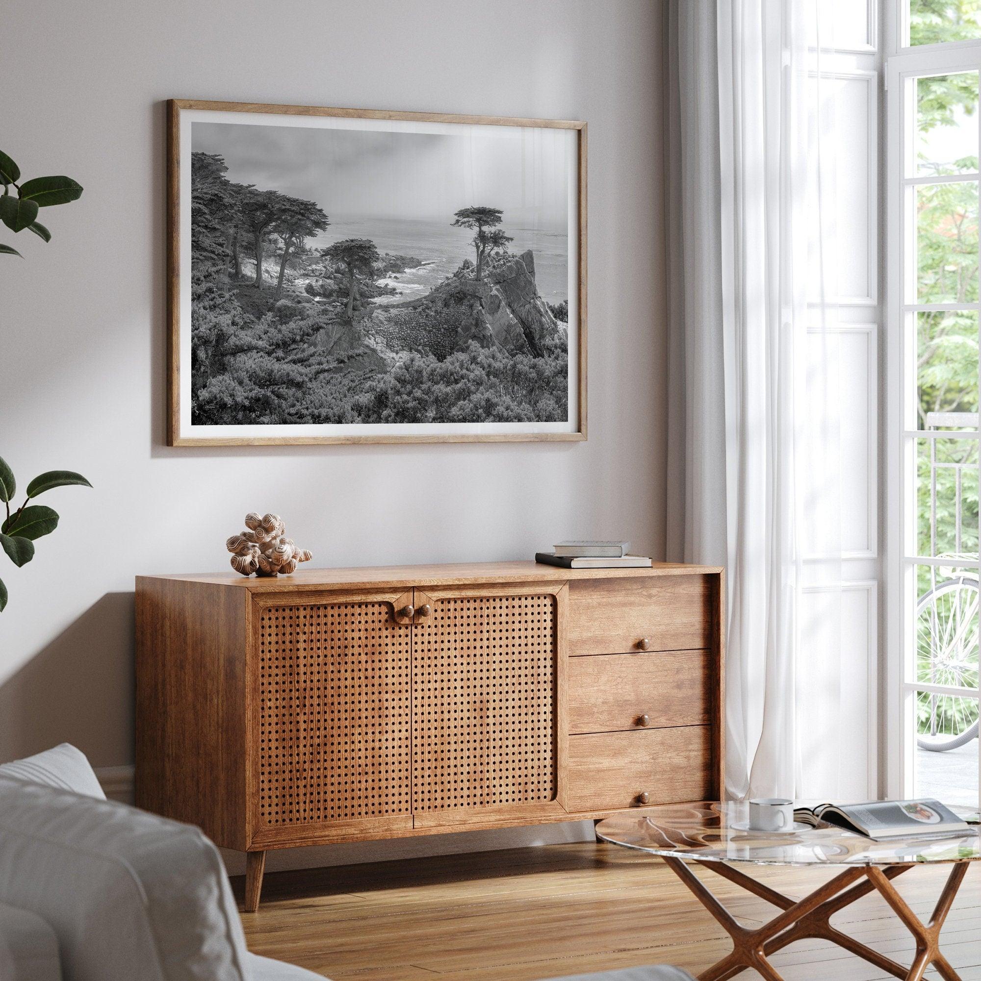 A fine art coastal black and white print showcasing a lone cypress overlooking the ocean in 17 mile drive near Monterey, California. This ocean wall art is available framed or unframed.