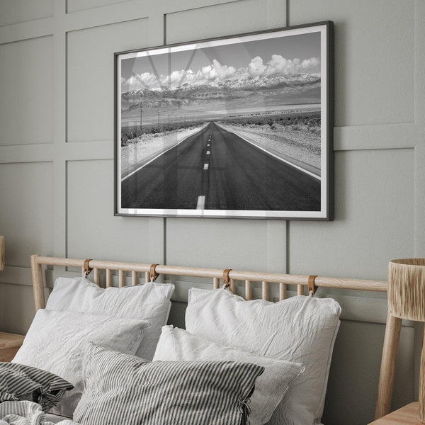 This stunning piece of black and white desert wall art will take your breath away. A beautifully framed picture of a Death Valley National Park road leading towards the snow-covered mountains at the end of the desert.