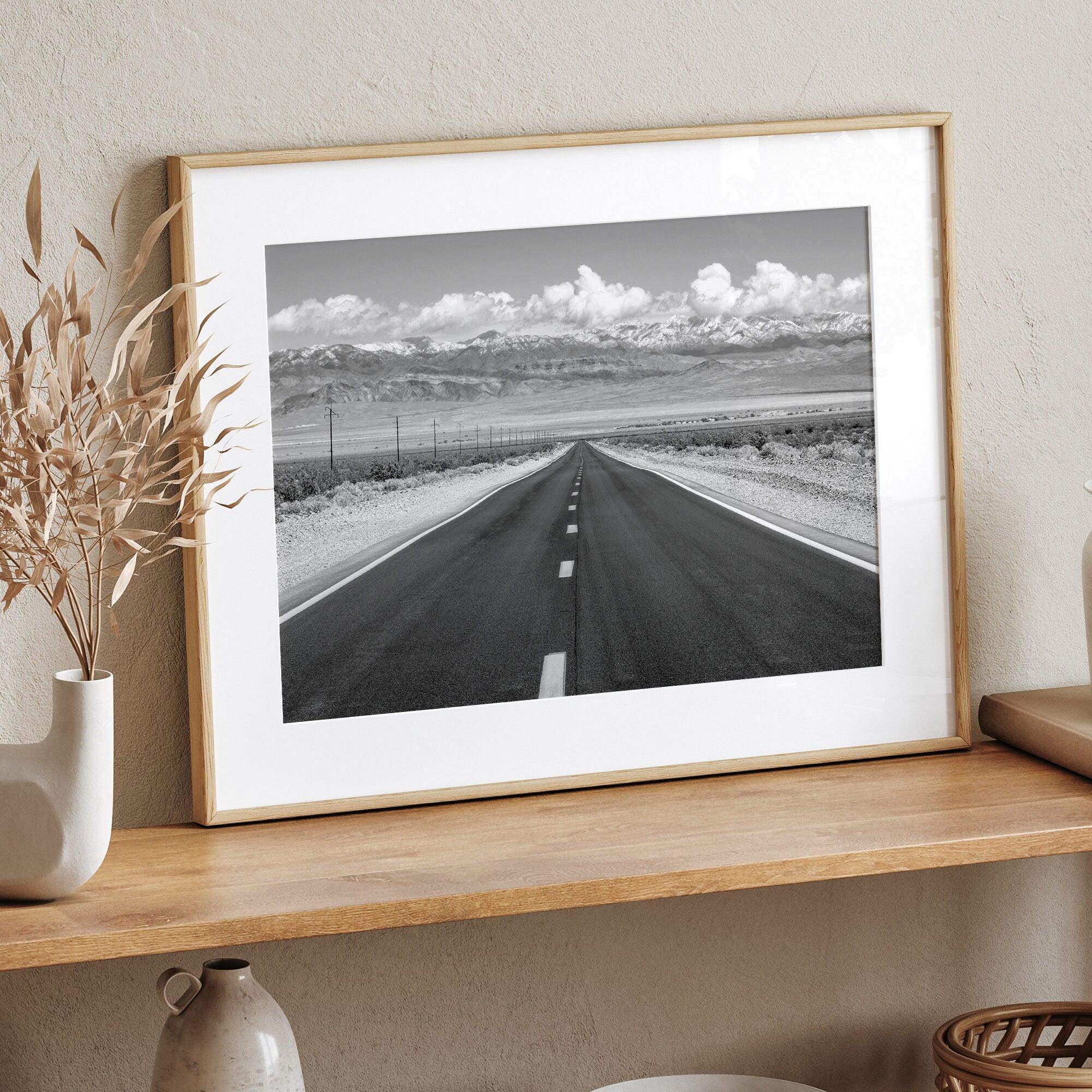 This stunning piece of black and white desert wall art will take your breath away. A beautifully framed picture of a Death Valley National Park road leading towards the snow-covered mountains at the end of the desert.