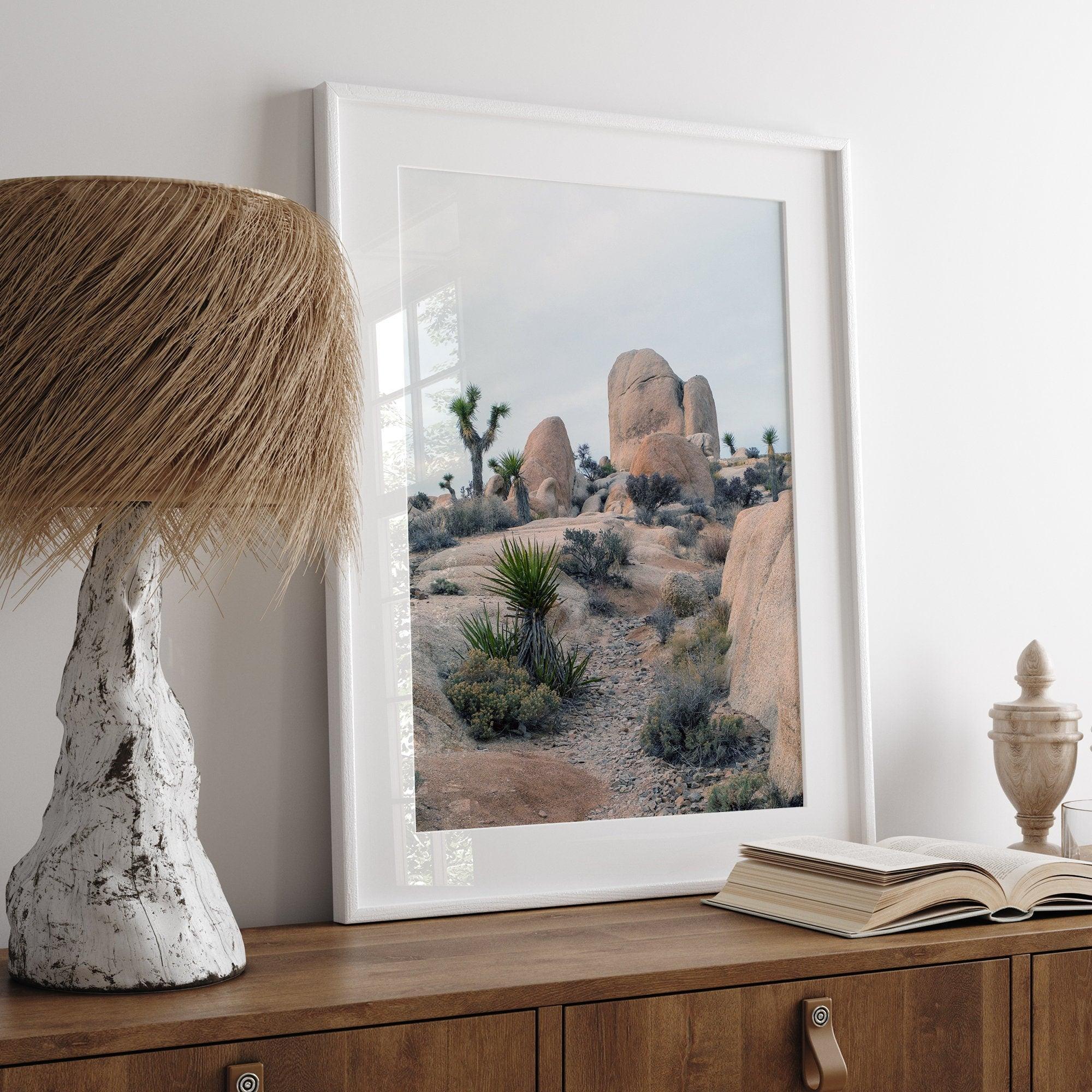 A fine art framed desert print featuring unique rock formations, desert plants, and Joshua Trees.