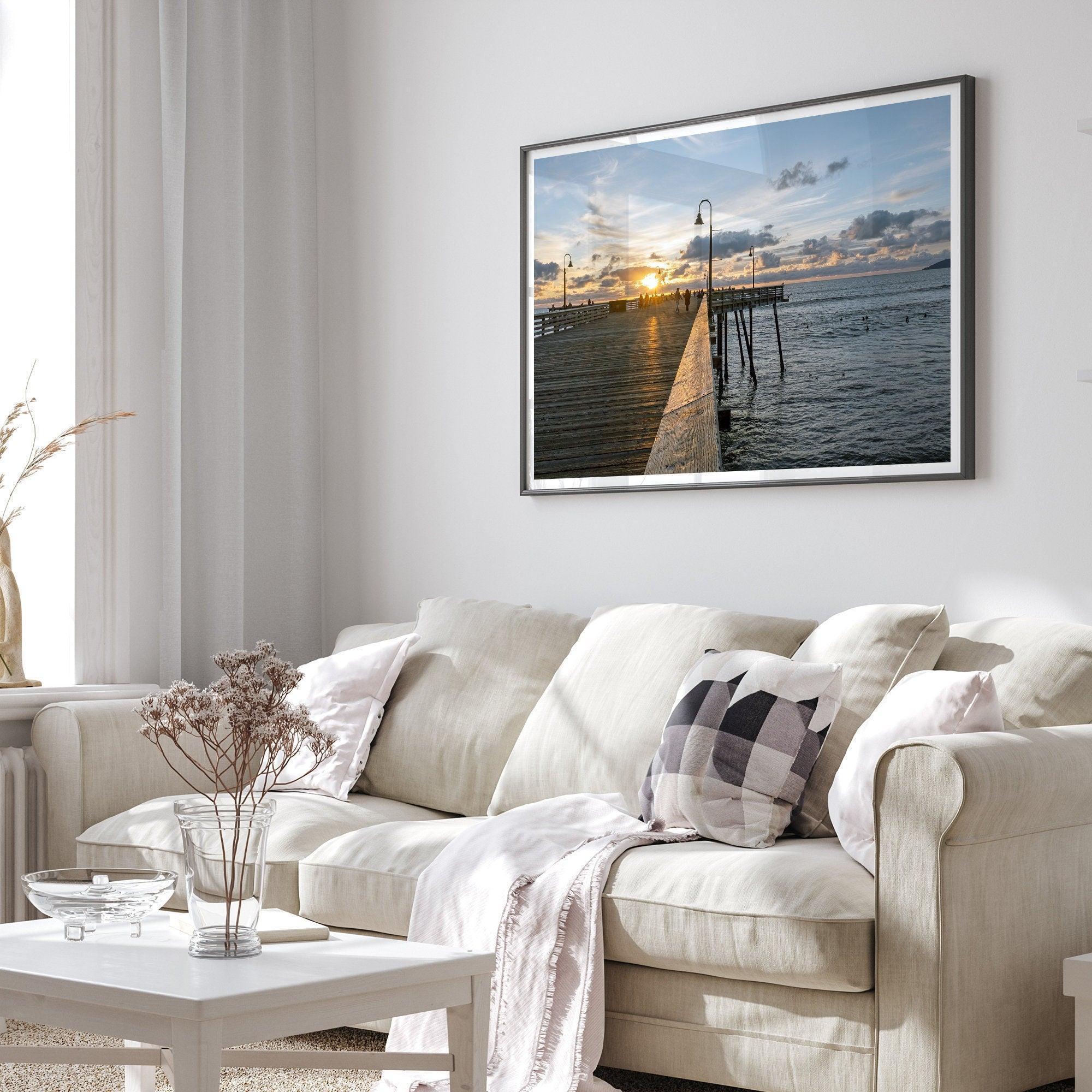 A fine art ocean sunset print featuring Pismo Beach Pier in Sunset with the surfers in the ocean and people enjoying a stroll on the pier.