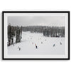 A fine art winter photography print of people skiing on the snow-covered Northstar Northern California mountain with snow-covered forest around.