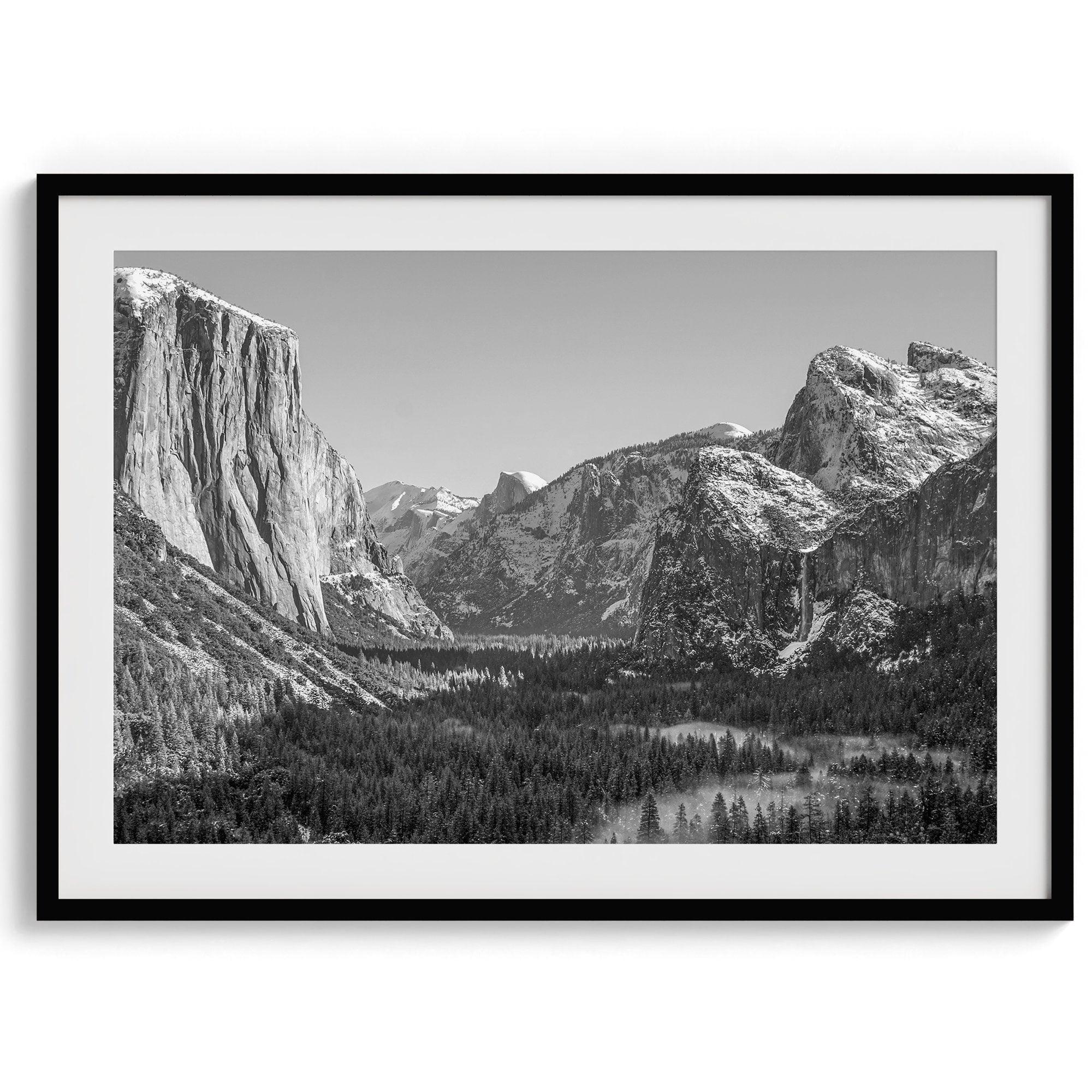 A fine art Yosemite Print featuring Yosemite Valley covered in snow in winter and a beautiful fog lays in the valley forest. This black and white mountain wall art is perfect for nature and fine art lovers.