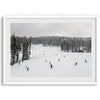 A fine art winter photography print of people skiing on the snow-covered Northstar Northern California mountain with snow-covered forest around.