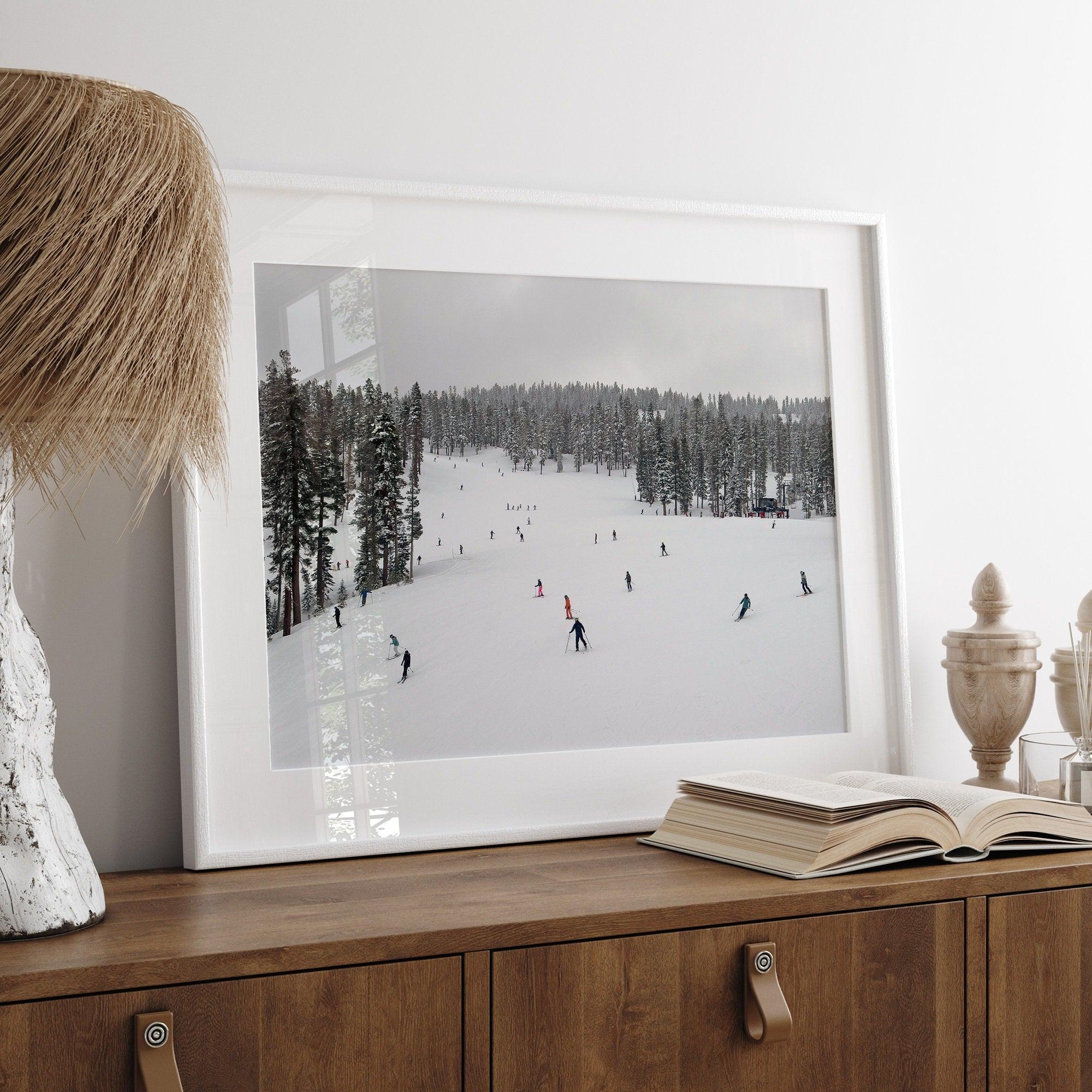 A fine art winter photography print of people skiing on the snow-covered Northstar Northern California mountain with snow-covered forest around.