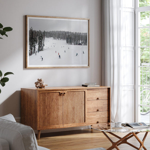 A fine art winter photography print of people skiing on the snow-covered Northstar Northern California mountain with snow-covered forest around.