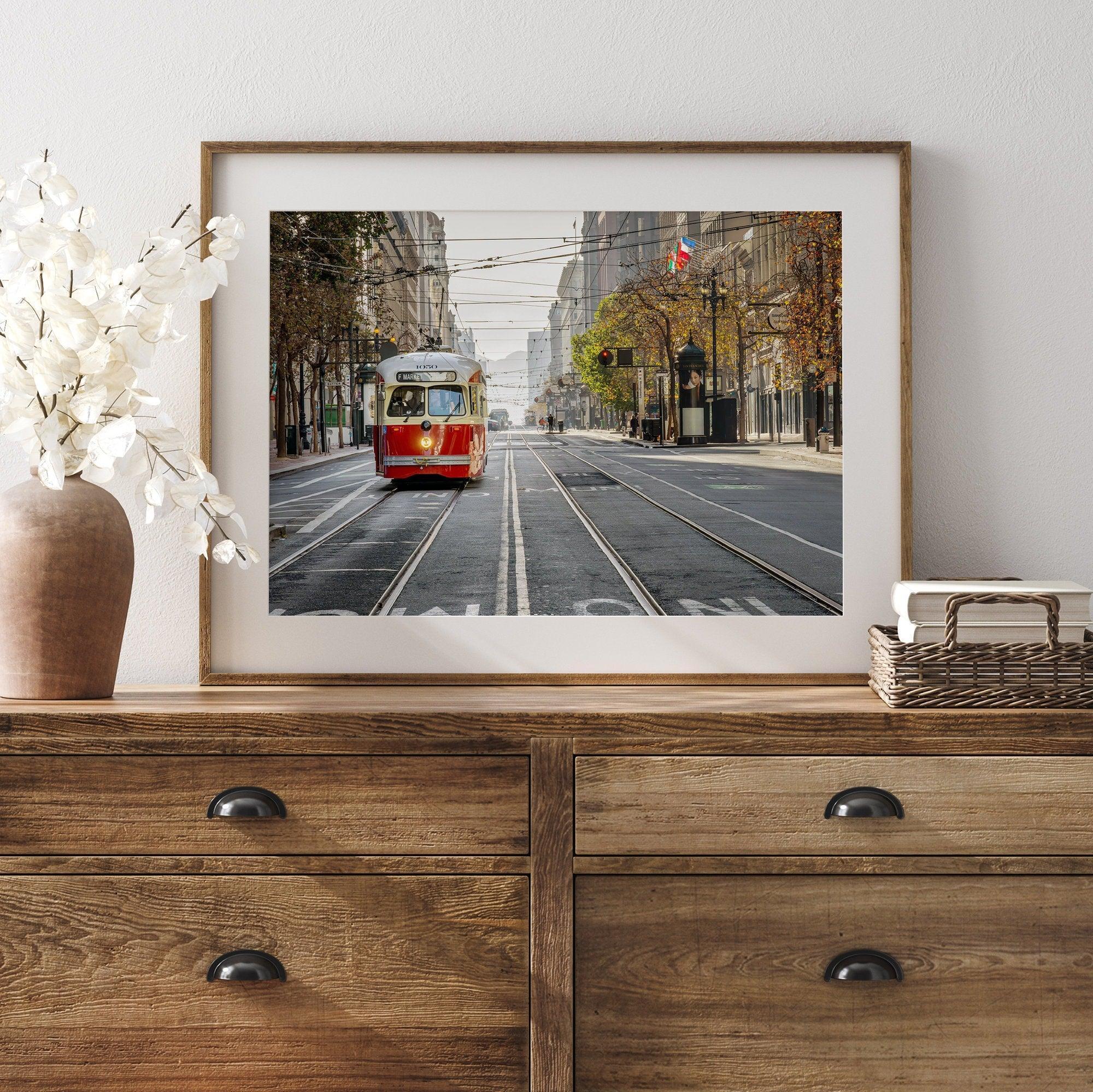 Fine art photograph of a cable car on Market Street in San Francisco, during golden hour. The image shows SF architecture, people, and the interplay of light and shadow.