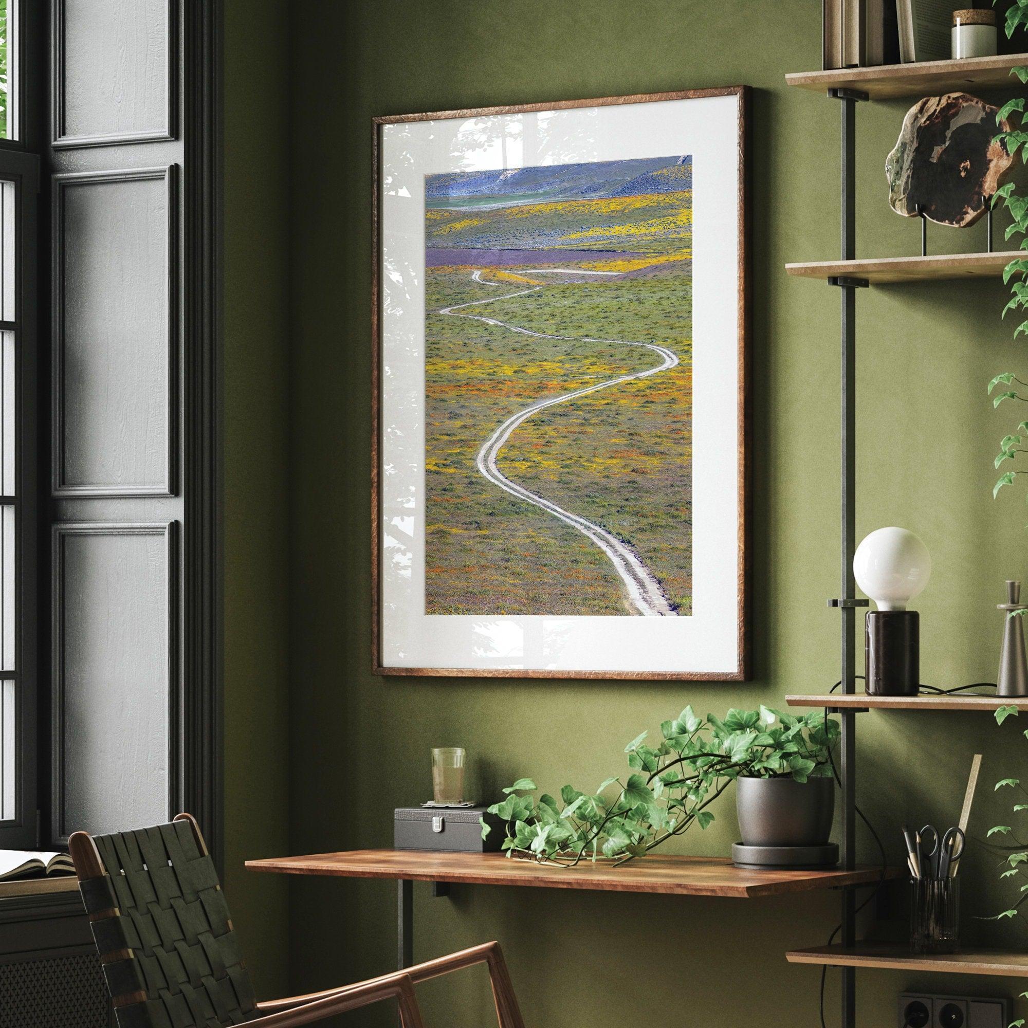 Vertical, fine art photography print of a winding road disappearing into a valley filled with colorful wildflowers in Antelope Valley, California.