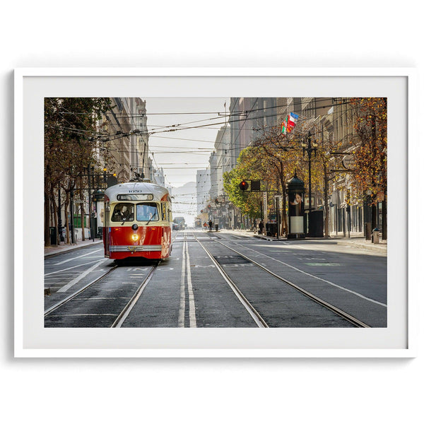 Fine art photograph of a cable car on Market Street in San Francisco, during golden hour. The image shows SF architecture, people, and the interplay of light and shadow.