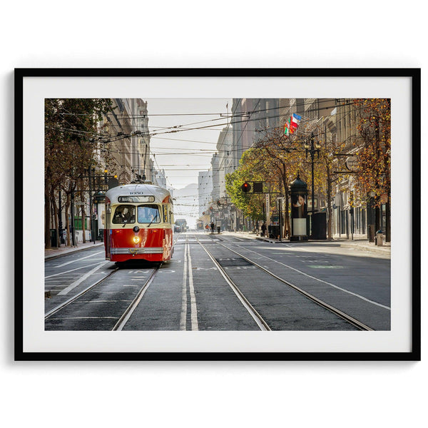 Fine art photograph of a cable car on Market Street in San Francisco, during golden hour. The image shows SF architecture, people, and the interplay of light and shadow.
